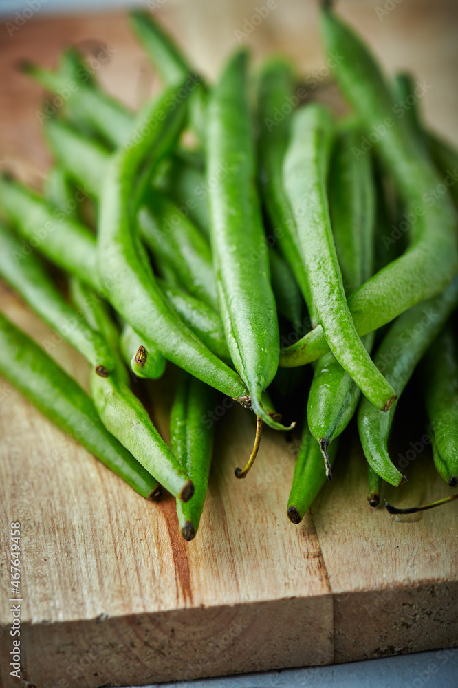 Fresh green beans on on wooden cutting board., closeup Fresh green beans on on wooden cutting board., closeup