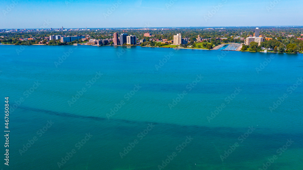 Aerial view of the Detroit River / riverbed with Erma Henderson Marina and Park along with various condo and  apartment buildings in the background. 