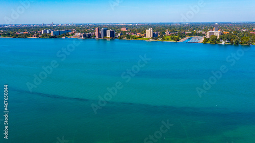Aerial view of the Detroit River   riverbed with Erma Henderson Marina and Park along with various condo and  apartment buildings in the background. 