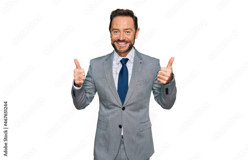 Middle age man wearing business clothes success sign doing positive gesture with hand, thumbs up smiling and happy. cheerful expression and winner gesture. Middle age man wearing business clothes success sign doing positive gesture with hand, thumbs up smiling and happy. cheerful expression and winner gesture.
