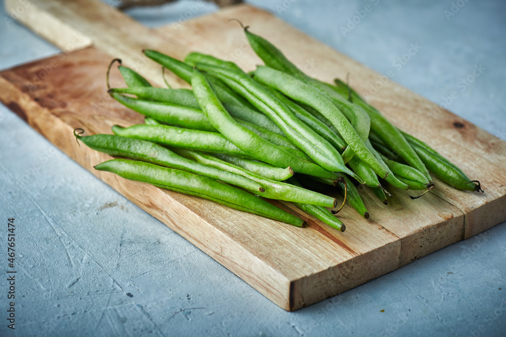Fresh green beans on on wooden cutting board., closeup Fresh green beans on on wooden cutting board., closeup
