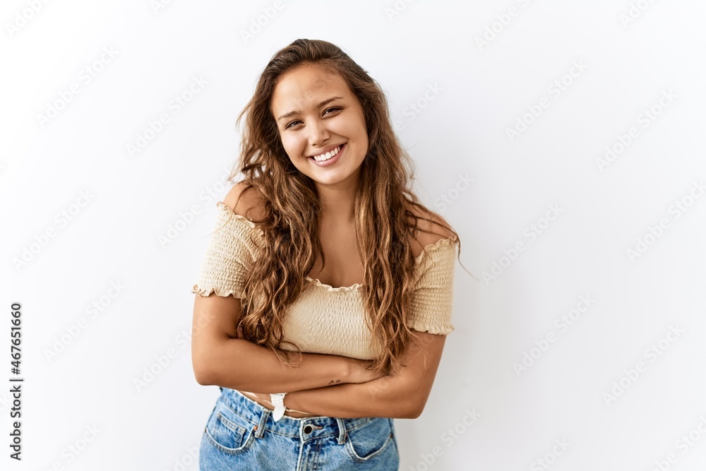 Beautiful hispanic woman standing over isolated while background happy face smiling with crossed arms looking at the camera. positive person. Beautiful hispanic woman standing over isolated while background happy face smiling with crossed arms looking at the camera. positive person.