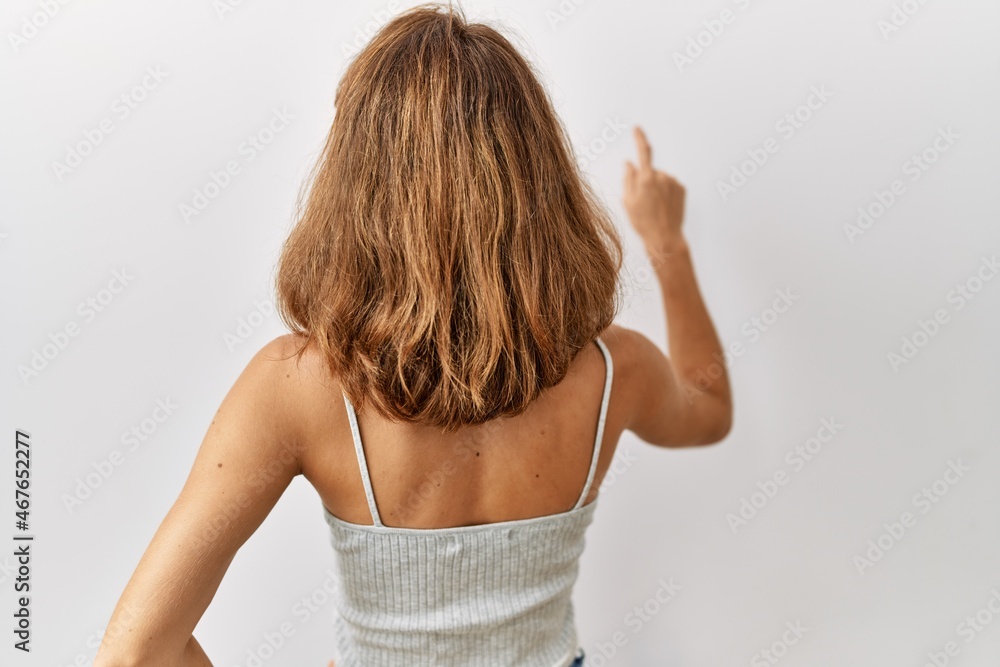 Beautiful caucasian woman standing over isolated background posing backwards pointing ahead with finger hand Beautiful caucasian woman standing over isolated background posing backwards pointing ahead with finger hand