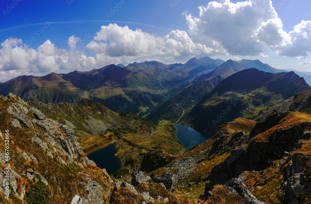 Obraz premium wide view to two dark blue mountain lakes and a colorful mountain range panorama