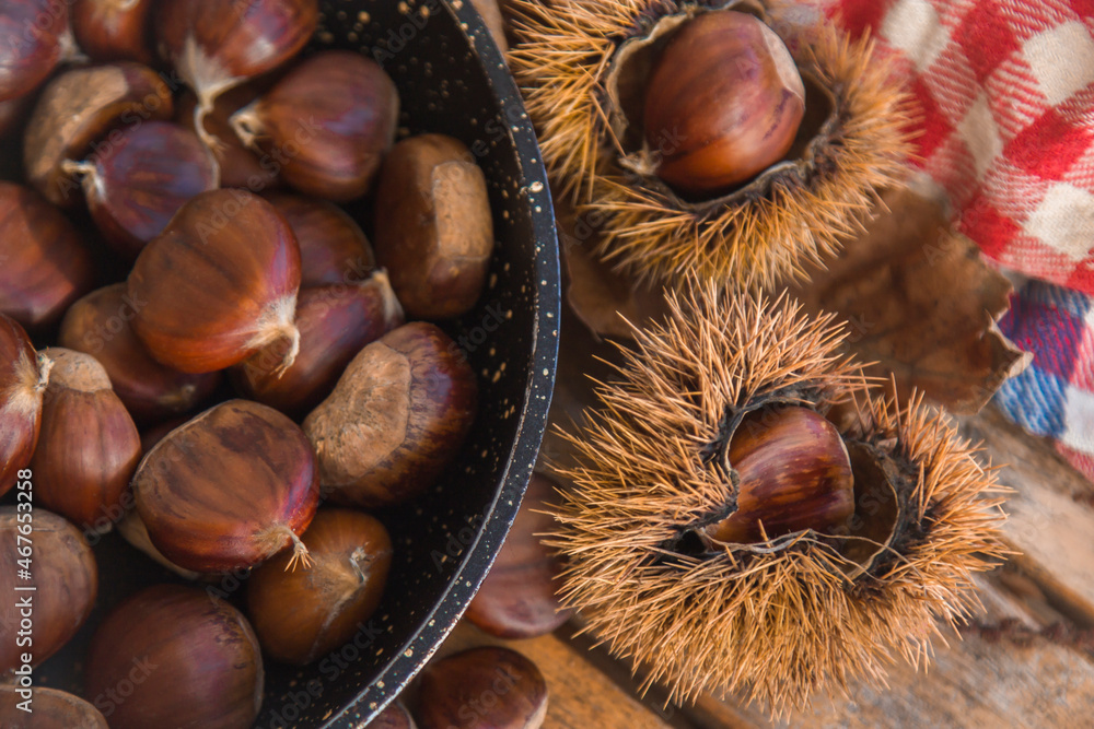 natural chestnuts in the pan with wooden background natural chestnuts in the pan with wooden background