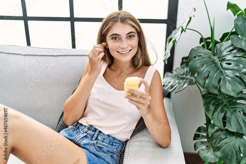 Young caucasian woman smiling confident using earphones at home