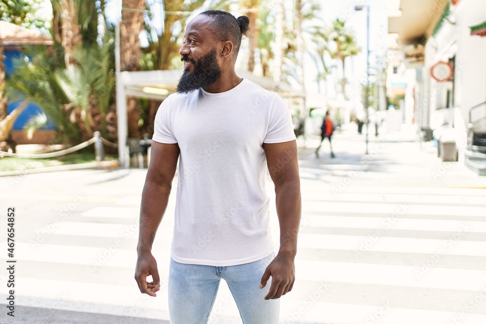 Handsome african american man with beard wearing casual white t shirt outdoors on a sunny day Handsome african american man with beard wearing casual white t shirt outdoors on a sunny day
