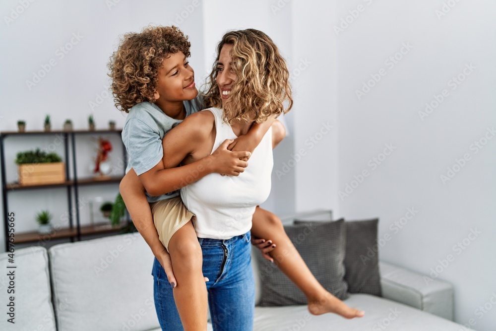 Mother and son smiling confident holding kid on back at home Mother and son smiling confident holding kid on back at home