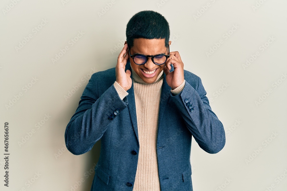 Obraz premium Young handsome hispanic man wearing elegant clothes and glasses covering ears with fingers with annoyed expression for the noise of loud music. deaf concept.