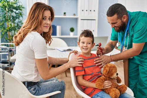 Family having medical consultation examining ear at clinic photo