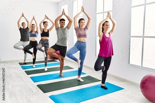 Group of young people smiling happy training yoga at sport center.