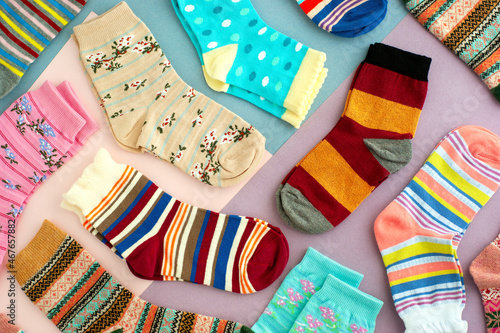 Colorful socks on a multicolored background. Many different socks for fall and winter. Knitted clothes in the form of bright socks.