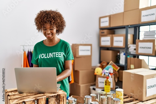 Young african american woman wearing volunteer uniform working at charity center