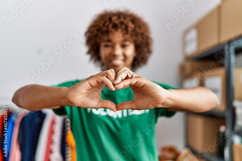 Murais de parede Young african american woman wearing volunteer uniform doing heart symbol with h