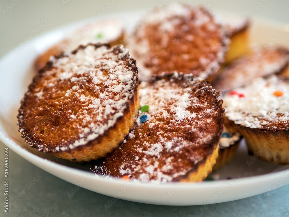 Low calorie gluten and lactose free cornmeal muffins with raisins and fructose sprinkle on a whithe plate. Healthy vegetarian desserts, dairy free. Close-up