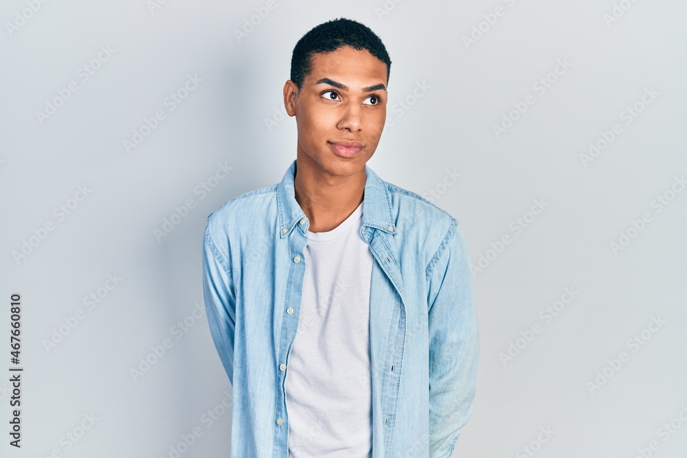 Young african american guy wearing casual clothes smiling looking to the side and staring away thinking. Young african american guy wearing casual clothes smiling looking to the side and staring away thinking.