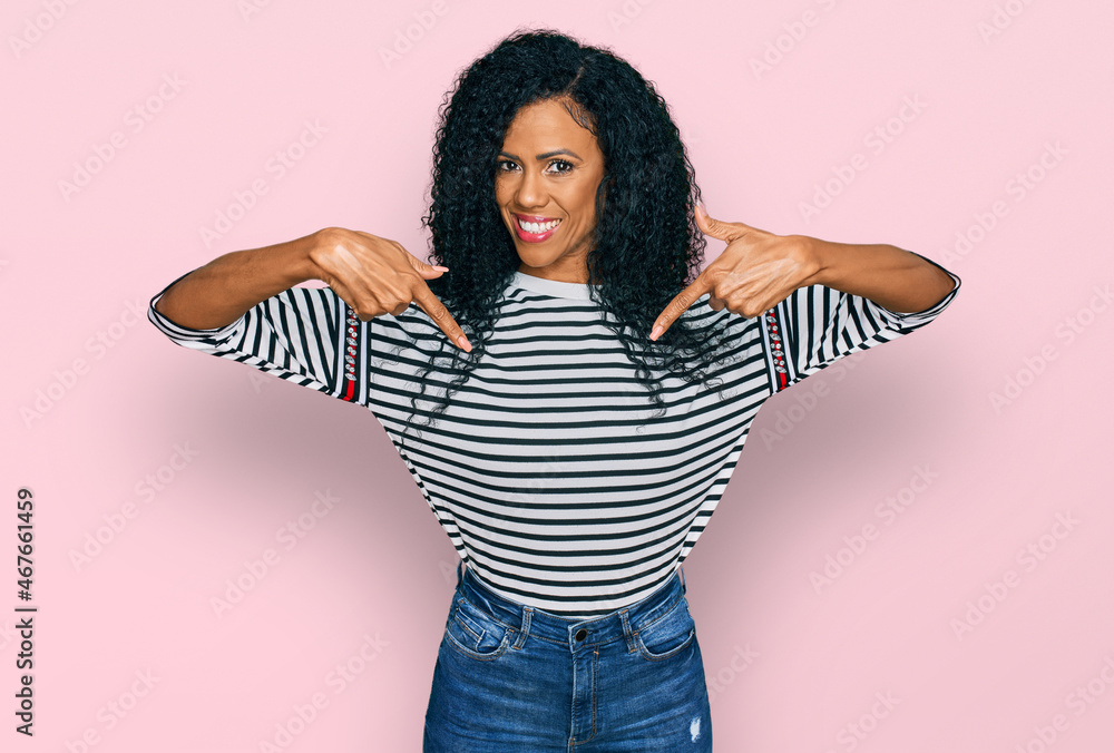 Middle age african american woman wearing casual clothes looking confident with smile on face, pointing oneself with fingers proud and happy. Middle age african american woman wearing casual clothes looking confident with smile on face, pointing oneself with fingers proud and happy.