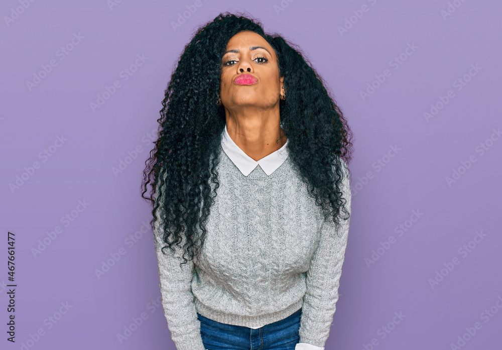 Middle age african american woman wearing casual clothes looking at the camera blowing a kiss on air being lovely and sexy. love expression. Middle age african american woman wearing casual clothes looking at the camera blowing a kiss on air being lovely and sexy. love expression.