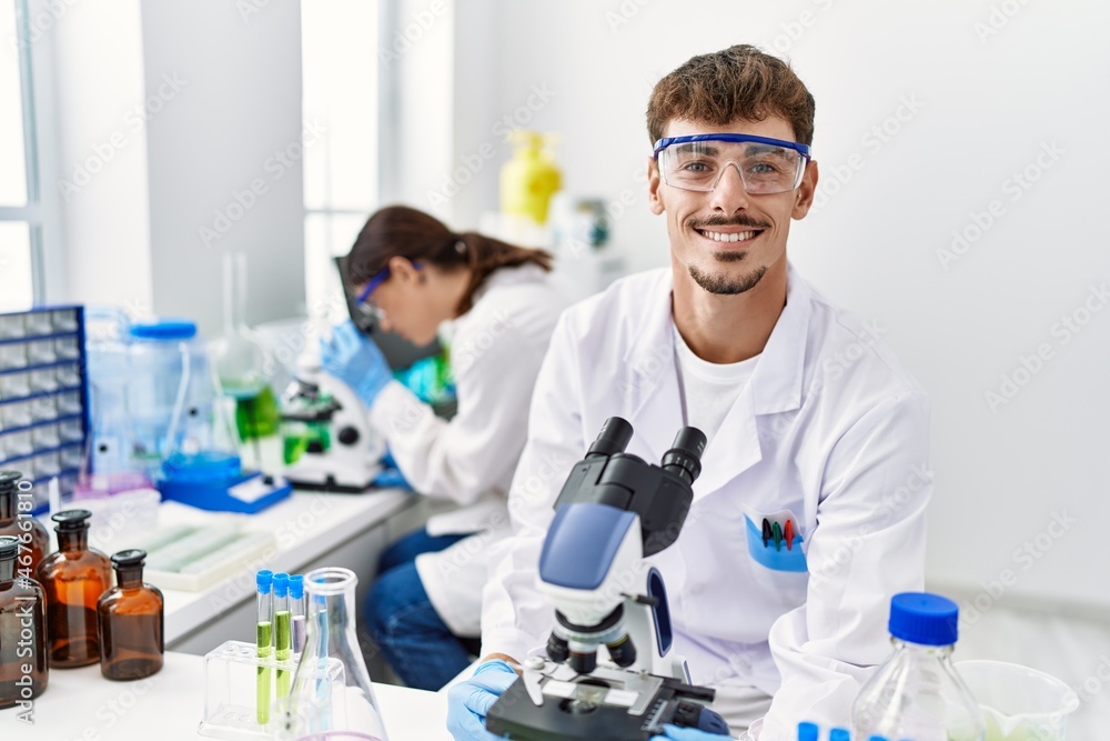 Man and woman partners wearing scientist uniform working at laboratory Man and woman partners wearing scientist uniform working at laboratory