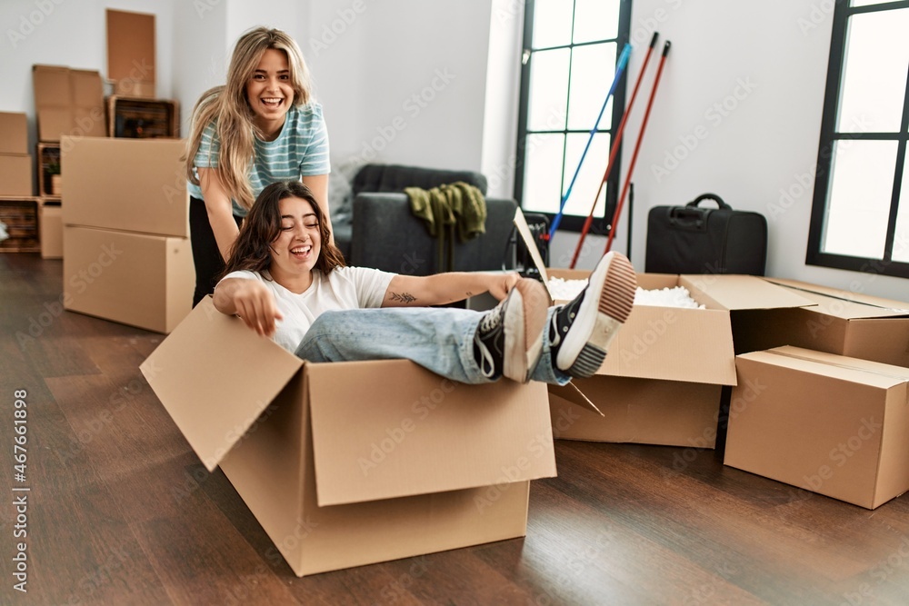 Young couple smiling happy playing using cardboard box as a car at new home. Young couple smiling happy playing using cardboard box as a car at new home.