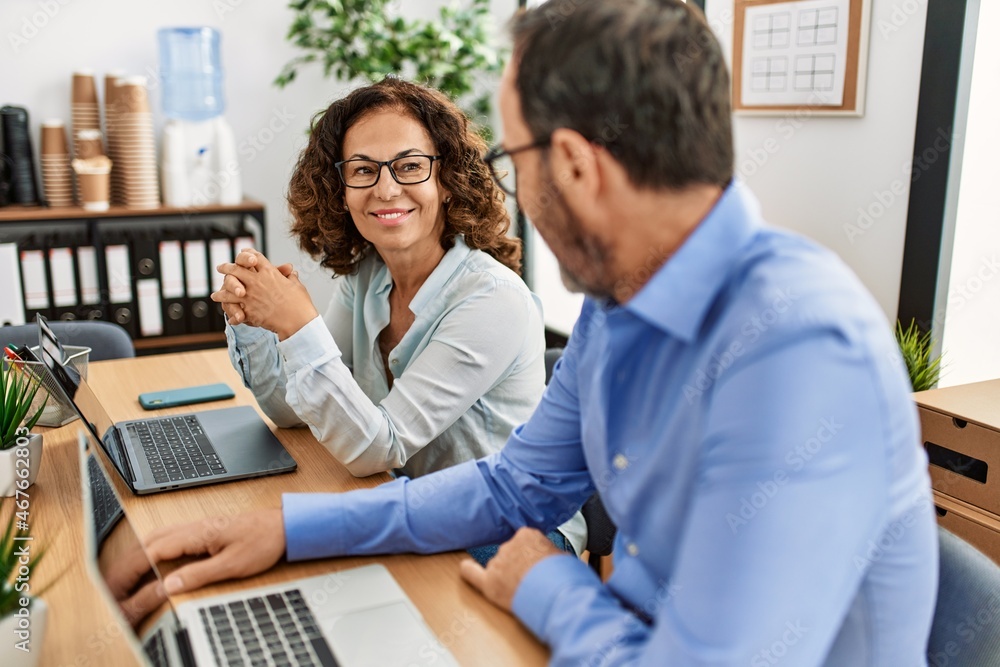 Two middle age business workers smiling happy working at the office. Two middle age business workers smiling happy working at the office.