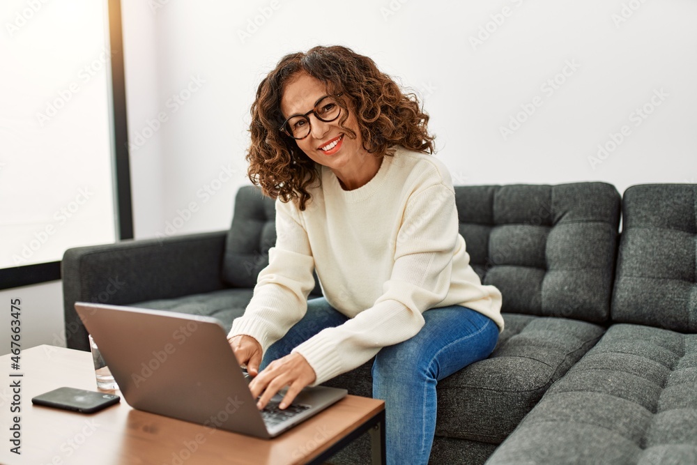 Middle age hispanic woman smiling confident using laptop at home Middle age hispanic woman smiling confident using laptop at home