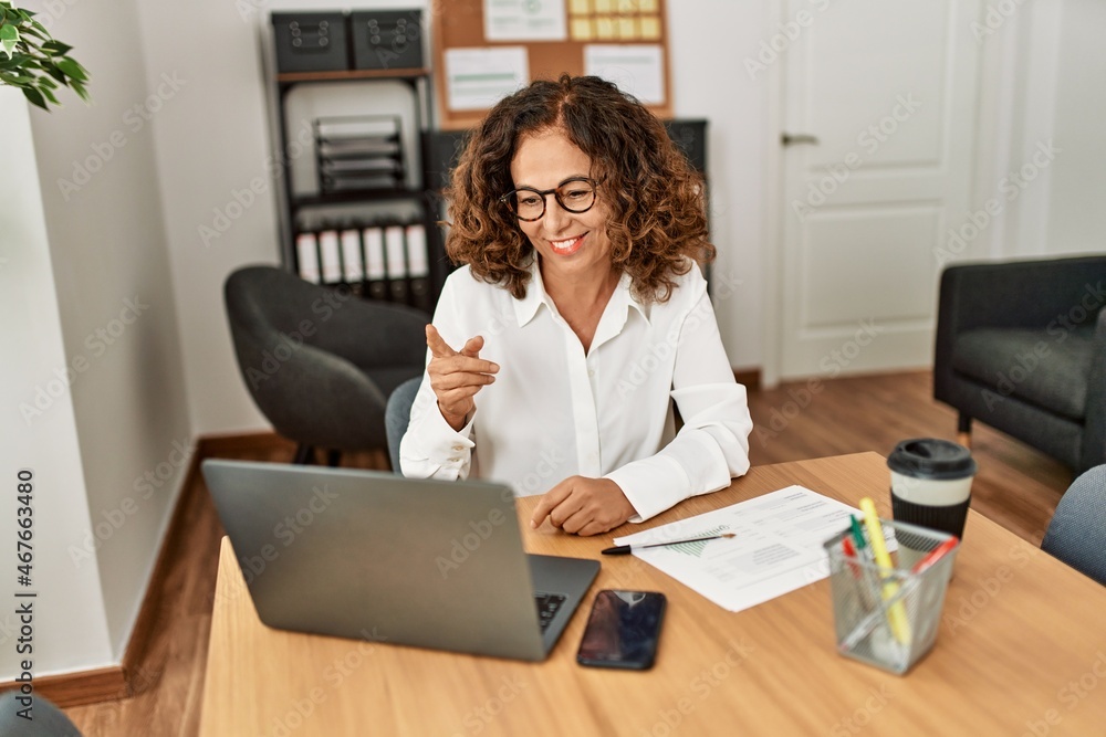 Middle age hispanic woman smiling confident having video call at office Middle age hispanic woman smiling confident having video call at office