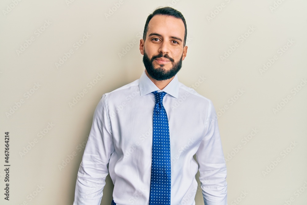 Young man with beard wearing business tie relaxed with serious expression on face. simple and natural looking at the camera. Young man with beard wearing business tie relaxed with serious expression on face. simple and natural looking at the camera.