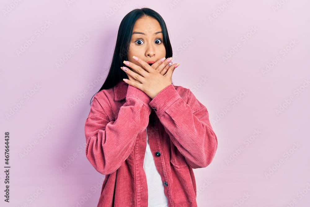 Obraz premium Beautiful hispanic woman with nose piercing wearing casual pink jacket shocked covering mouth with hands for mistake. secret concept.