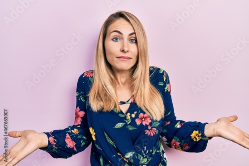 Young caucasian woman wearing casual clothes clueless and confused expression with arms and hands raised. doubt concept.
