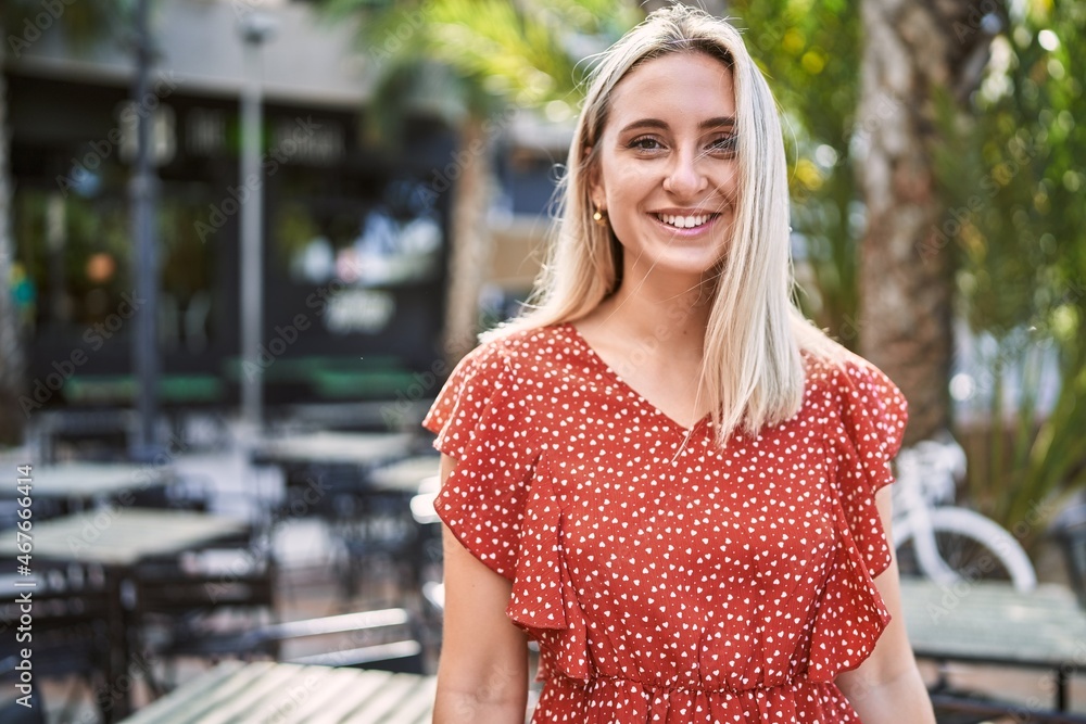 Fototapeta premium Young blonde girl smiling happy standing at the city.