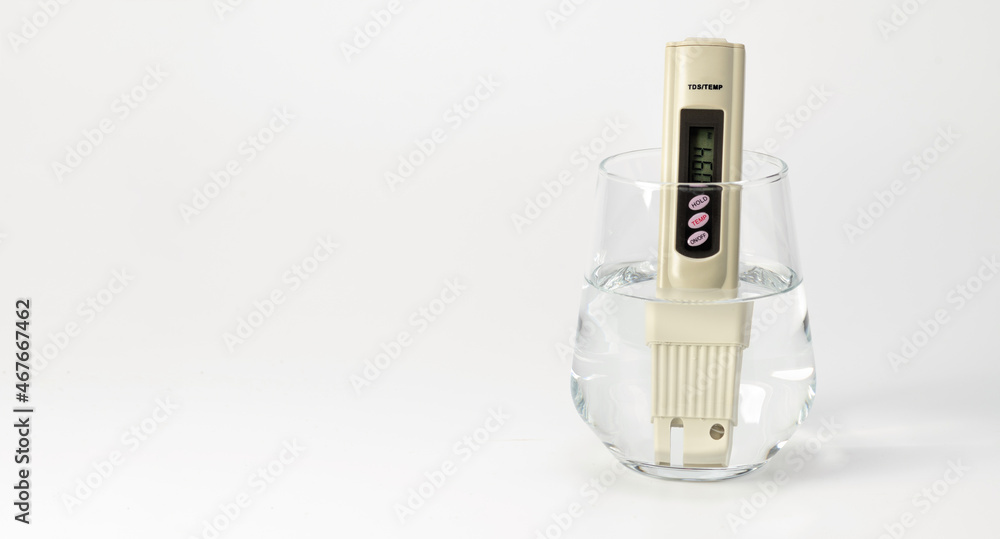 TDS meter saline meter in a glass of water on a white background. Salt counter. Drinking water quality analyzer. Place for text TDS meter saline meter in a glass of water on a white background. Salt counter. Drinking water quality analyzer. Place for text