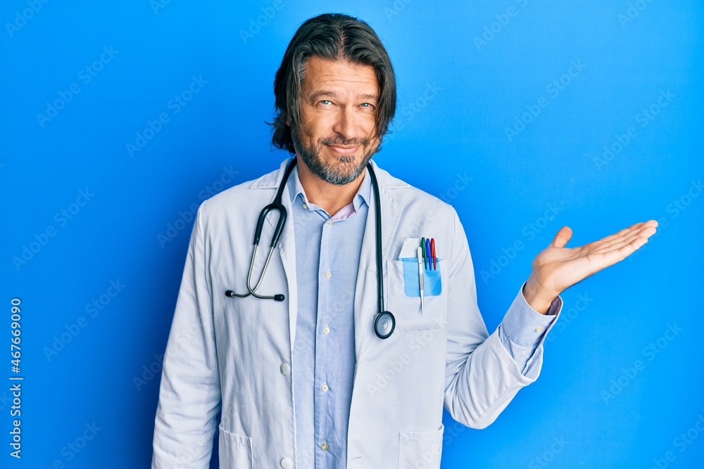 Middle age handsome man wearing doctor uniform and stethoscope smiling cheerful presenting and pointing with palm of hand looking at the camera. Middle age handsome man wearing doctor uniform and stethoscope smiling cheerful presenting and pointing with palm of hand looking at the camera.