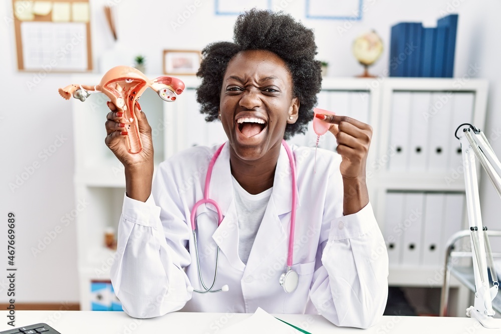 African doctor woman holding anatomical female genital organ and