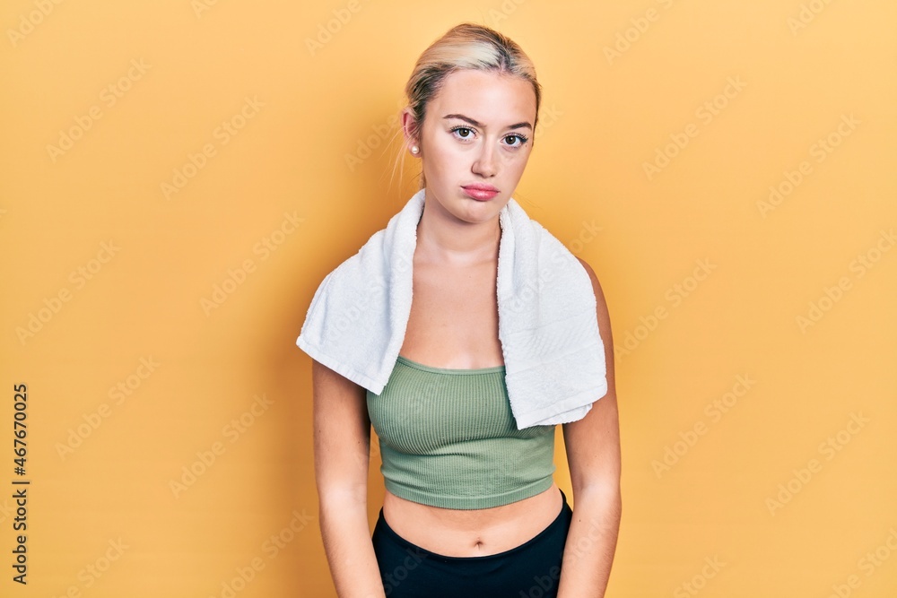 Young blonde girl wearing sportswear and towel looking sleepy and tired, exhausted for fatigue and hangover, lazy eyes in the morning. Young blonde girl wearing sportswear and towel looking sleepy and tired, exhausted for fatigue and hangover, lazy eyes in the morning.