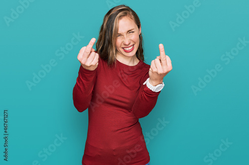 Quadro su tela Young blonde woman wearing casual clothes showing middle finger doing fuck you bad expression, provocation and rude attitude