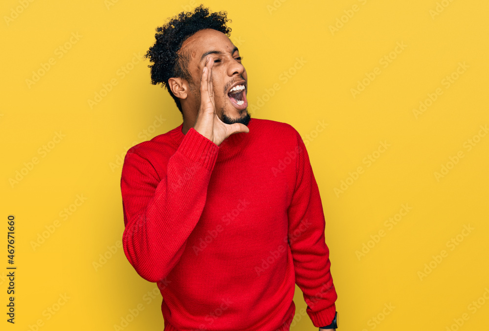 Young african american man with beard wearing casual winter sweater shouting and screaming loud to side with hand on mouth. communication concept.