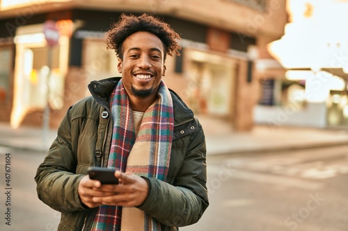 Young african american man smiling happy using smartphone at the city