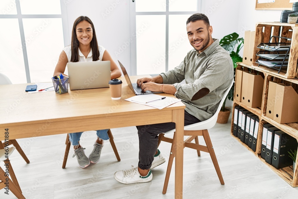 Two latin business workers smiling happy working at the office. Two latin business workers smiling happy working at the office.