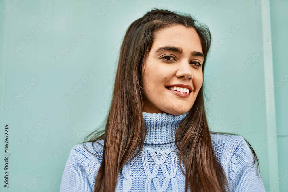 Fototapeta premium Young hispanic girl smiling happy standing at the city