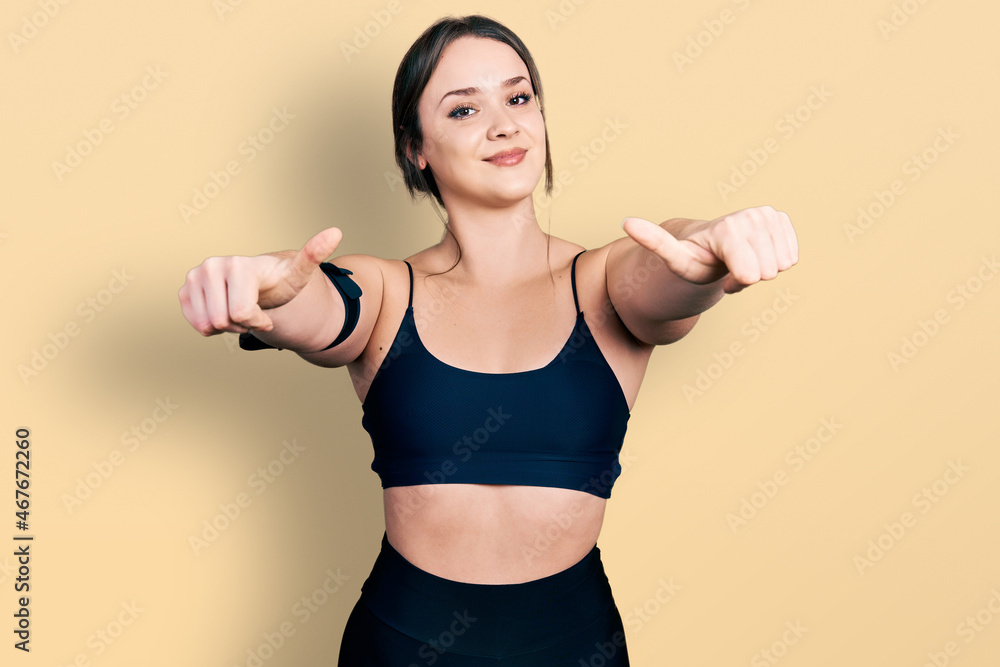 Young hispanic woman wearing sportswear approving doing positive gesture with hand, thumbs up smiling and happy for success. winner gesture. Young hispanic woman wearing sportswear approving doing positive gesture with hand, thumbs up smiling and happy for success. winner gesture.