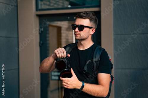 Man with a camera on the background of a residential building