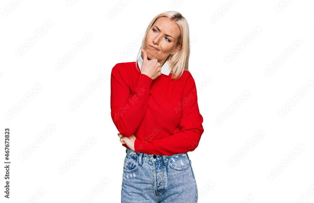 Young blonde woman wearing casual clothes serious face thinking about question with hand on chin, thoughtful about confusing idea