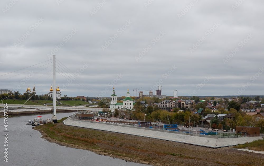 Fototapeta premium View from the granite embankment to the bridge of lovers in the city of Tyumen in autumn