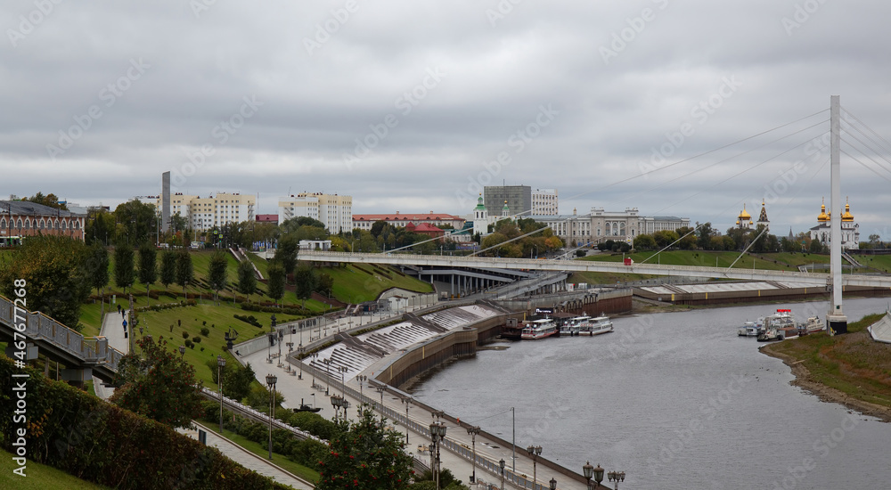 View from the granite embankment to the bridge of lovers in the city of Tyumen in autumn