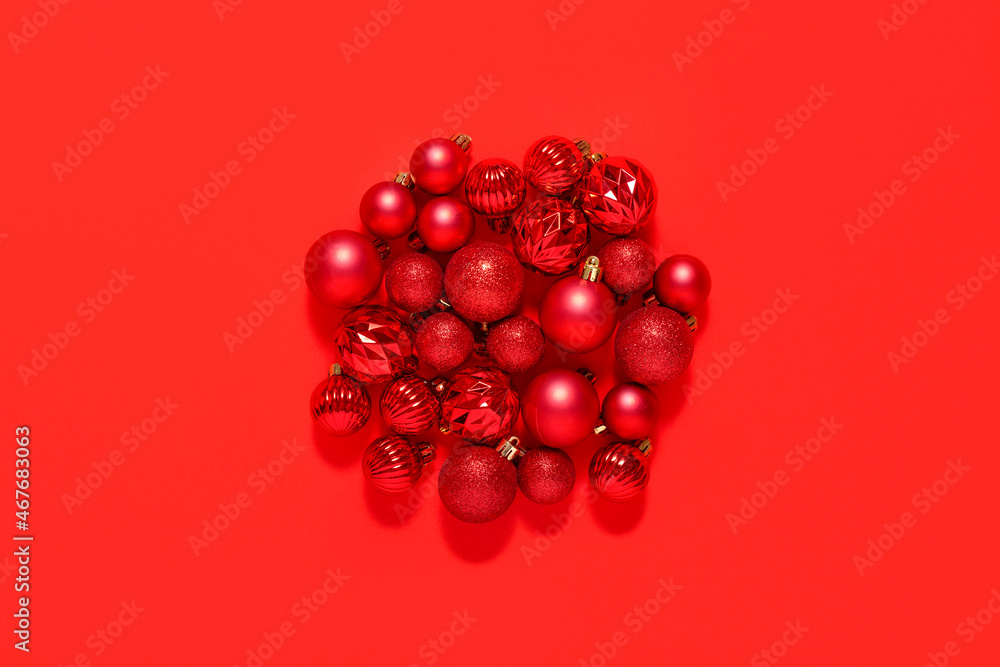 Beautiful red small decorative balls are scattered on a red background. Top view, flat lay. Beautiful red small decorative balls are scattered on a red background. Top view, flat lay.
