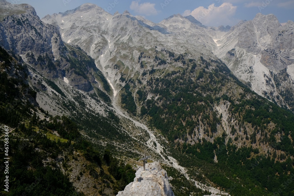 Metal cross on peak next to Valbona Pass (Qafa e Valbones) on trail from Theth Valley to Valbona Valley in Albanian Alps. It is one of the most beautiful high mountain trails.