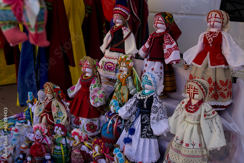Korosten', Ukraine - An open-air traditional craft fair on a city street. Shown are handmade dolls dressed in national clothes. Different sizes and different colors.