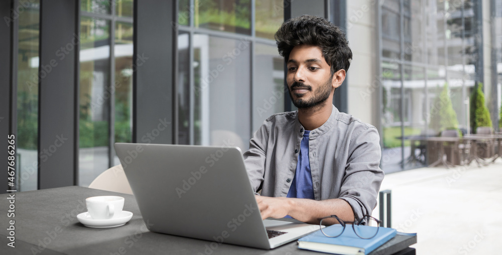 Confident businessman working on laptop at his workplace at modern office, Young handsome student men using laptop computer, Business, working moments, freelance, distance education concept Confident businessman working on laptop at his workplace at modern office, Young handsome student men using laptop computer, Business, working moments, freelance, distance education concept