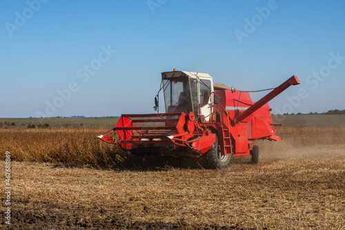 Red combine harvesting a crop of soybeans